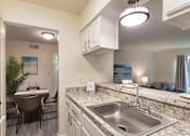 Thumbnail 3 of 43 - Kitchen pass-through and granite-style breakfast bar overlooking the dining and living area at The Summit at Midtown