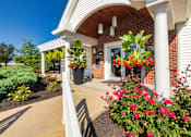 Thumbnail 59 of 75 - A house with a red brick exterior and a white porch.