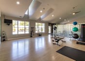 Thumbnail 52 of 75 - A spacious gym with wooden floors and various exercise equipment.