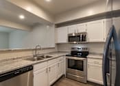 Thumbnail 3 of 61 - A kitchen with white cabinets and stainless steel appliances in the 1280 square foot, 2 bedroom, 2 and a half bath Oakwood floor plan  at Washington Park Apartments, in Centerville, OH.