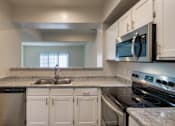 Thumbnail 4 of 61 - A kitchen with white cabinets and stainless steel appliances in the 1280 square foot, 2 bedroom, 2 and a half bath Oakwood floor plan  at Washington Park Apartments, in Centerville, OH.