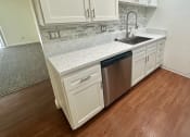 Thumbnail 30 of 54 - a kitchen with white cabinets and a stainless steel dishwasher at Camino de Oro Apartments, Torrance, CA, 90505