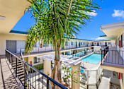 Thumbnail 2 of 19 - a balcony with a pool and a palm tree at Olive Tree Apartments, Torrance