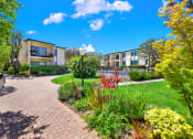 Thumbnail 9 of 36 - a view of a garden with a building in the background at Casa Del Amo Apartments, Torrance