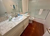 Thumbnail 18 of 26 - A bathroom with a marble countertop and a white sink.