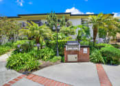 Thumbnail 9 of 54 - a building with a driveway and palm trees in front of it at Camino de Oro Apartments, California, 90505