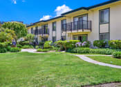 Thumbnail 11 of 54 - a yard in front of a building with grass and walk ways at Camino de Oro Apartments, Torrance, CA