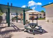 Thumbnail 10 of 54 - a patio with tables and umbrellas outside of a building at Camino de Oro Apartments, California, 90505