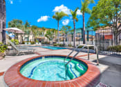 Thumbnail 4 of 54 - a jacuzzi pool with palm trees and a building in the background at Camino de Oro Apartments, Torrance, California