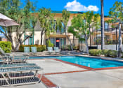 Thumbnail 2 of 54 - a swimming pool with chairs and a building in the background at Camino de Oro Apartments, California, 90505