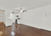 Thumbnail 44 of 54 - an empty living room with a ceiling fan and a kitchen at Camino de Oro Apartments, Torrance, CA, 90505