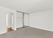 Thumbnail 46 of 54 - an empty living room with white walls and sliding glass doors to a closet at Camino de Oro Apartments, Torrance, California