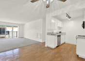 Thumbnail 33 of 54 - an empty living room with a kitchen and a balcony at Camino de Oro Apartments, Torrance, CA, 90505