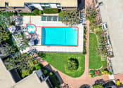 Thumbnail 4 of 36 - an aerial view of a pool and a yard with a tennis court at Casa Del Amo Apartments, California, 90505