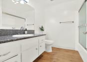 Thumbnail 31 of 36 - a bathroom with a sink and a toilet and a shower at Casa Del Amo Apartments, Torrance