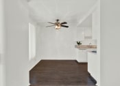 Thumbnail 24 of 26 - a living room with a ceiling fan and a kitchen at Casa De Oro Apartments, California, 90505