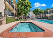 Thumbnail 6 of 26 - a resort style pool is next to an apartment building at Casa De Oro Apartments, Torrance, CA