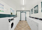 Thumbnail 7 of 26 - a washer and dryer in a laundry room with washing machines at Casa De Oro Apartments, Torrance, 90505