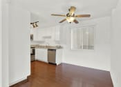 Thumbnail 22 of 26 - an empty living room and kitchen with a ceiling fan at Casa De Oro Apartments, Torrance