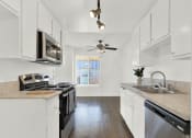 Thumbnail 21 of 26 - a kitchen with white cabinets and stainless steel appliances at Casa De Oro Apartments, Torrance, CA
