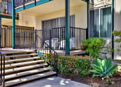Thumbnail 17 of 36 - steps leading up to a building with a patio and plants at Copa Ladeene Apartments, Torrance, CA