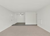 Thumbnail 28 of 36 - an empty living room with white walls and a ceiling fan at Copa Ladeene Apartments, California
