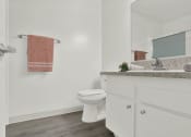 Thumbnail 33 of 36 - a bathroom with a toilet and a sink and a mirror at Copa Ladeene Apartments, Torrance