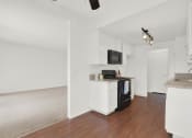 Thumbnail 24 of 36 - a kitchen with white cabinets and a black stove at Copa Ladeene Apartments, Torrance, CA 90505