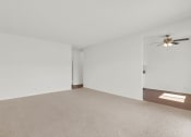 Thumbnail 26 of 36 - an empty living room with white walls and a ceiling fan at Copa Ladeene Apartments, Torrance, 90505