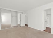 Thumbnail 29 of 36 - an empty living room with mirrored closet doors and carpet at Copa Ladeene Apartments, Torrance, CA
