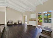 Thumbnail 11 of 26 - a living room with wooden floors and a door to a balcony at Copa Triana Apartments, Torrance