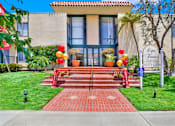 Thumbnail 7 of 26 - the front of a building with stairs and a sign in front at Copa Triana Apartments, California