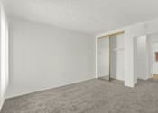 Thumbnail 23 of 26 - an empty living room with white walls and a door to a closet at Copa Triana Apartments, Torrance, CA