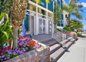 Thumbnail 3 of 18 - a building with palm trees and flowers in front of it  at Royal Towers Apartments, Redondo Beach, 90277