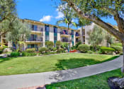 Thumbnail 12 of 55 - a sidewalk in front of an apartment building with grass and trees at Willow Tree Apartments, Torrance, CA