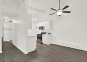 Thumbnail 26 of 55 - a living room with a ceiling fan and a kitchen at Willow Tree Apartments, Torrance