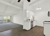 Thumbnail 27 of 55 - an open kitchen and living room with white walls and wood floors  at Willow Tree Apartments, Torrance, CA, 90505