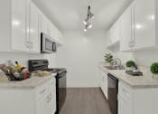 Thumbnail 22 of 55 - a white kitchen with white cabinets and black appliances  at Willow Tree Apartments, Torrance, CA, 90505
