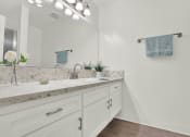 Thumbnail 28 of 55 - a white bathroom with a sink and a mirror at Willow Tree Apartments, Torrance, CA