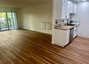 Thumbnail 44 of 55 - A kitchen with white cabinets and a wooden floor. at Willow Tree Apartments, California, 90505