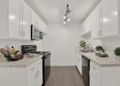 Thumbnail 19 of 36 - a kitchen with white cabinets and white counter tops and black appliances at Casa Del Amo Apartments, Torrance, CA 90505