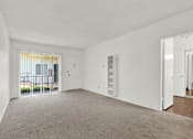 Thumbnail 15 of 19 - an empty living room with a door to a balcony at Olive Tree Apartments, Torrance California