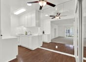 Thumbnail 13 of 19 - a kitchen with white cabinets and a ceiling fan at Olive Tree Apartments, California, 90503