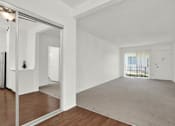 Thumbnail 14 of 19 - a living room with white walls and a mirrored door at Olive Tree Apartments, Torrance, 90503