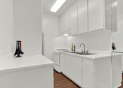 Thumbnail 17 of 19 - a kitchen with white cabinets and a sink and a refrigerator at Olive Tree Apartments, Torrance, 90503