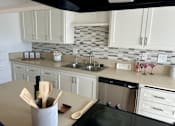 Thumbnail 13 of 18 - A kitchen with a black stove top oven and a white counter top at Royal Towers Apartments, Redondo Beach, CA, 90277