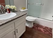 Thumbnail 14 of 26 - A bathroom with a sink, toilet, and shower.  at Casa De Oro Apartments, Torrance, 90505