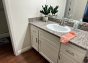 Thumbnail 13 of 26 - A bathroom with a sink, a mirror, and a potted plant.  at Casa De Oro Apartments, Torrance, 90505