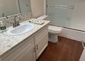 Thumbnail 19 of 26 - A bathroom with a sink, toilet, and shower.  at Casa De Oro Apartments, Torrance, 90505