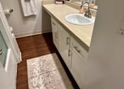 Thumbnail 17 of 18 - A bathroom with a sink, mirror, and wooden floor at Royal Towers Apartments, Redondo Beach, CA, 90277